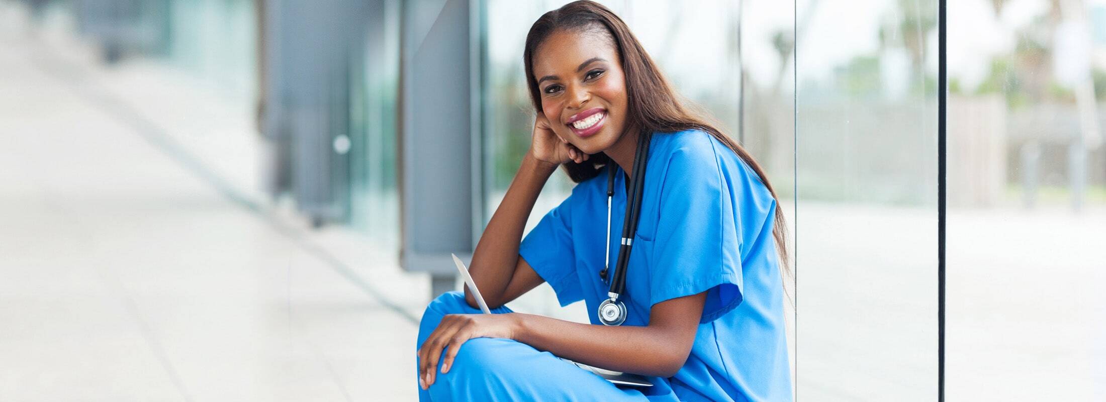 banner-clinician-seated-hallway-smiling-min