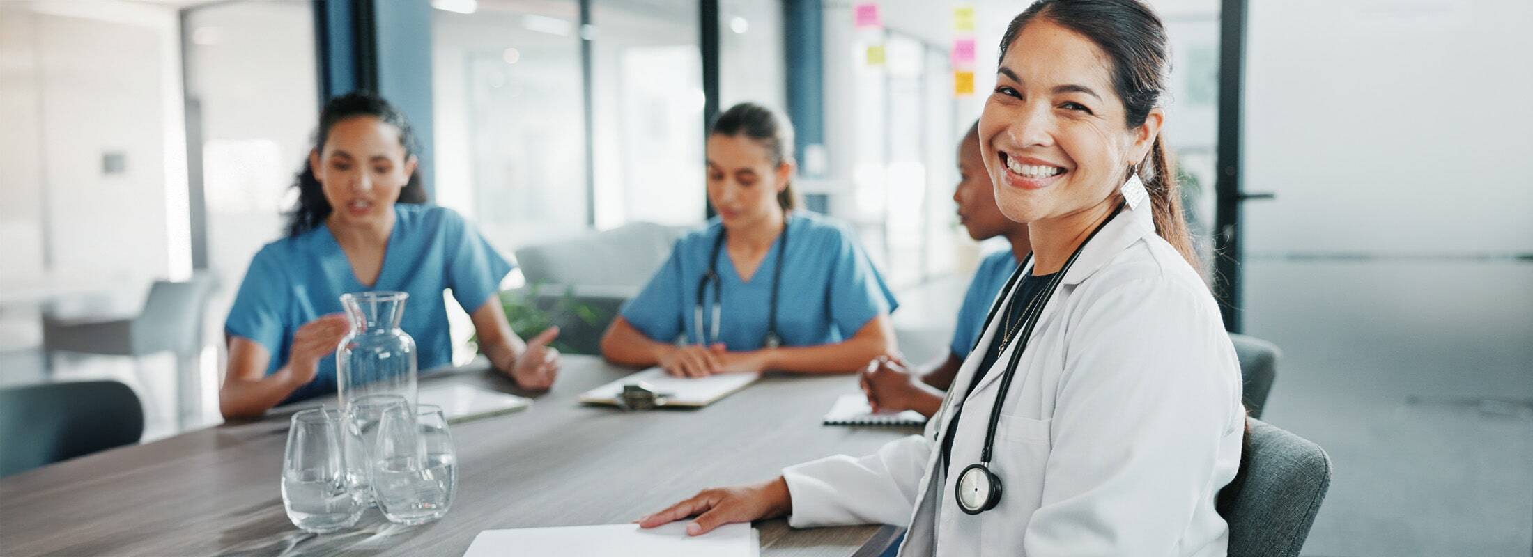 banner-doctor-smiling-nurses-table-min